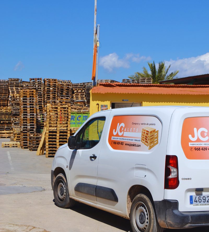 Furgoneta de reparto JC Palets con datos de contacto en el exterior de las instalaciones